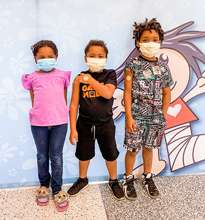 3 kids showing they received their COVID vaccine