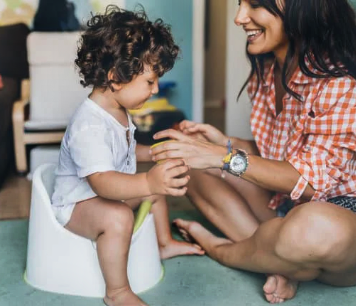 Child on a potty with mom helping