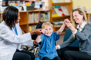 Doctor and Caregiver Helping Child Stand