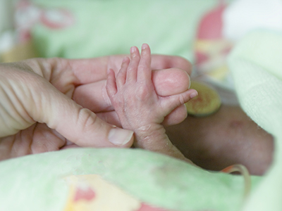 Hands: Mom and baby holding each other's hands.