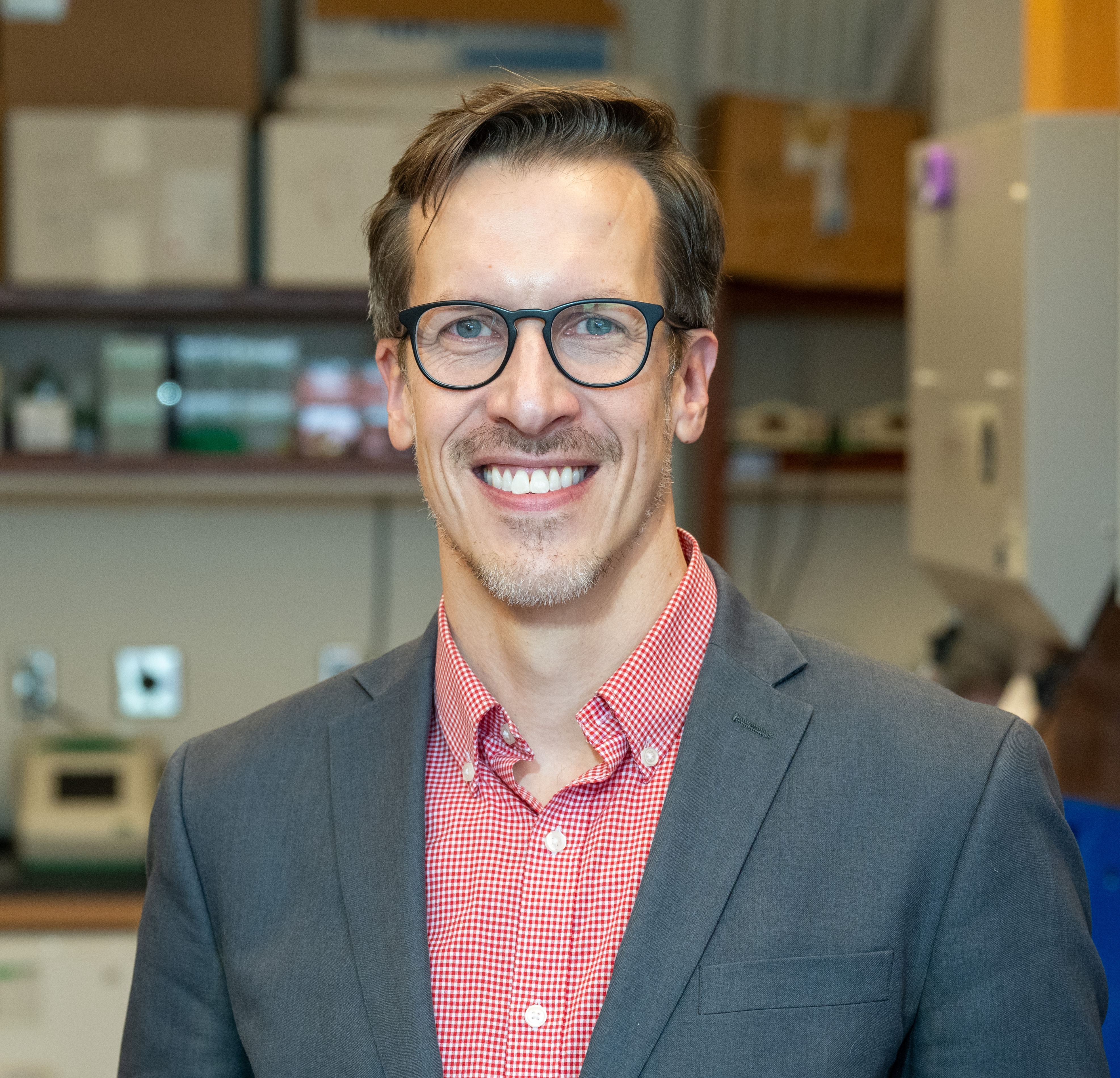 Person wearing glasses smiling at camera