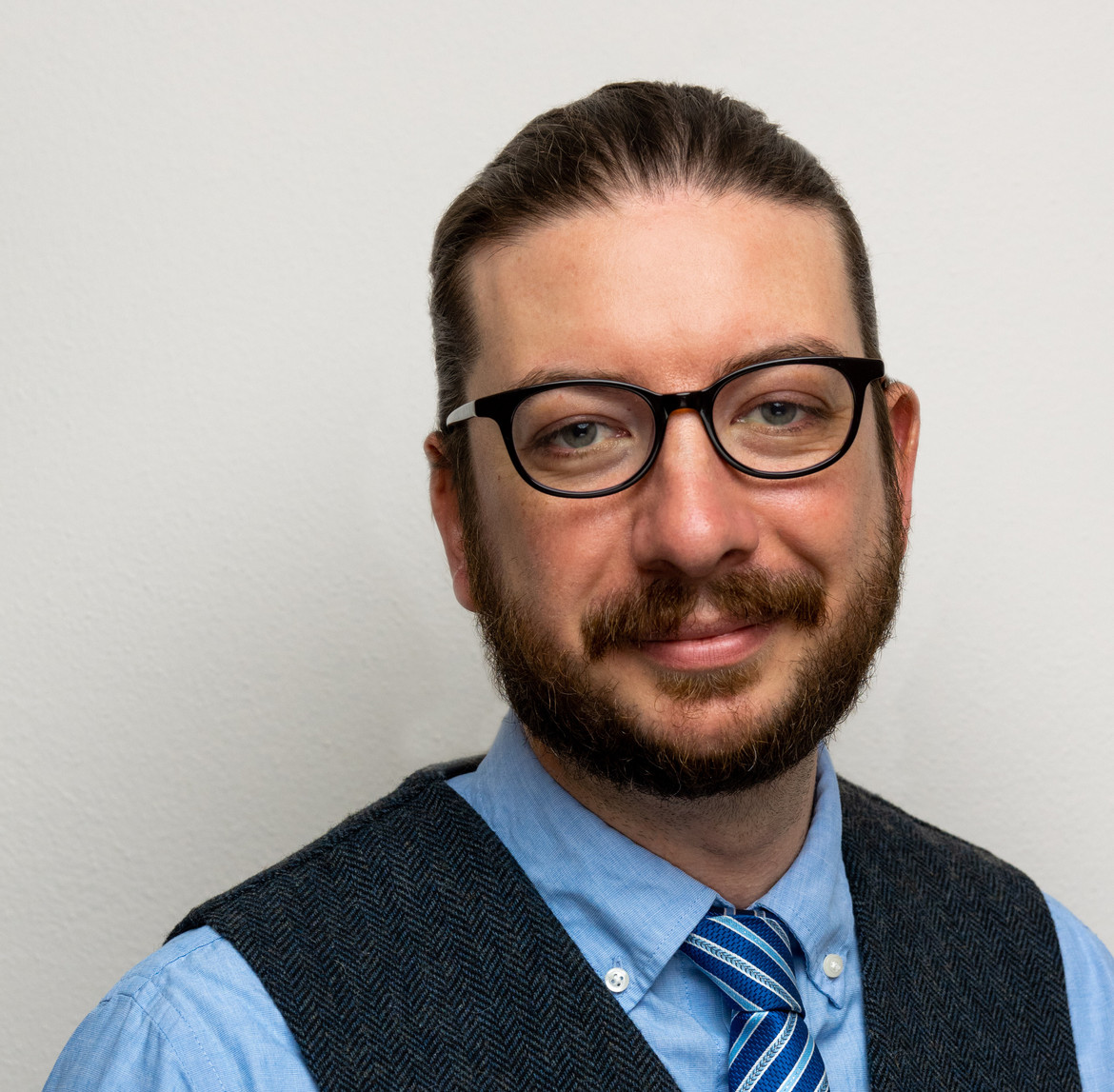 Person wearing glasses smiling at camera