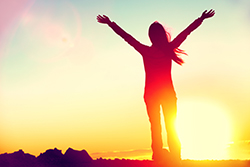 Woman standing in front of sun