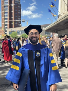 Abdullah Almulhim in gown and hat at commencement