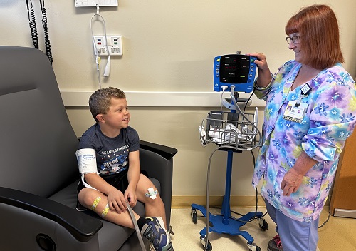 Nurse Ann Miller and a young patient at the Clinical Research Center