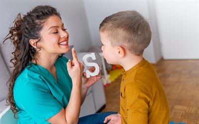 Photo of researcher signing to autistic child