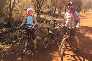 Man and woman on bikes in sun