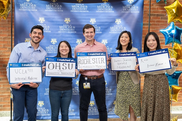 Medical students holding signs where they matched
