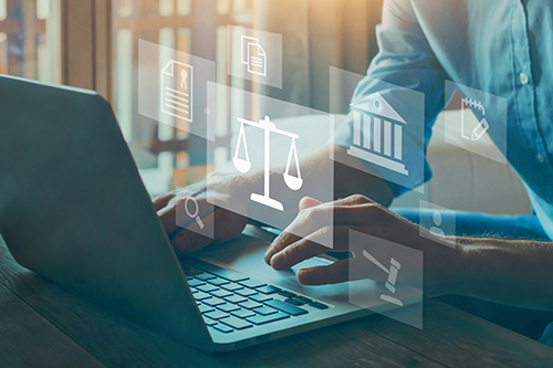 legal symbols with a person looking at a laptop
