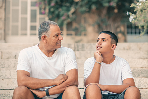 a older man talking to a teenager