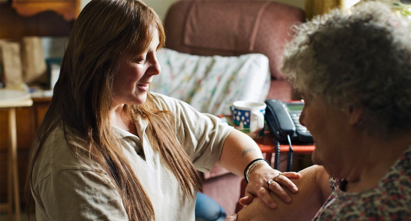 Woman holding arm of a female patient doing a checkup