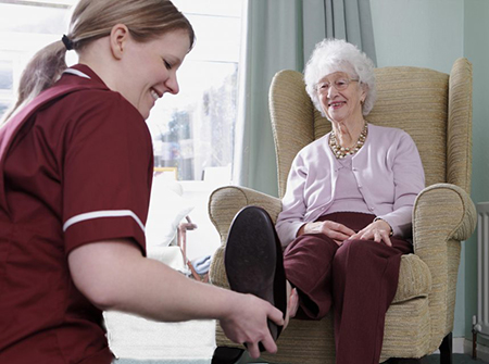 Home health aide helping woman