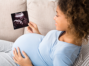 Pregnant woman looking at ultrasound image