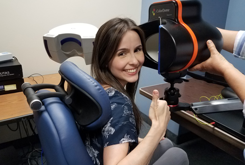 women patient smiling getting set up with testing machine by another person