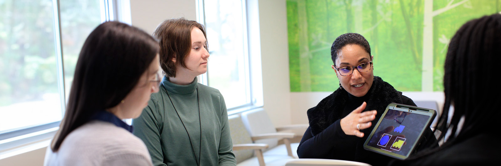 Arielle Sheftall and lab researchers looking at ipad