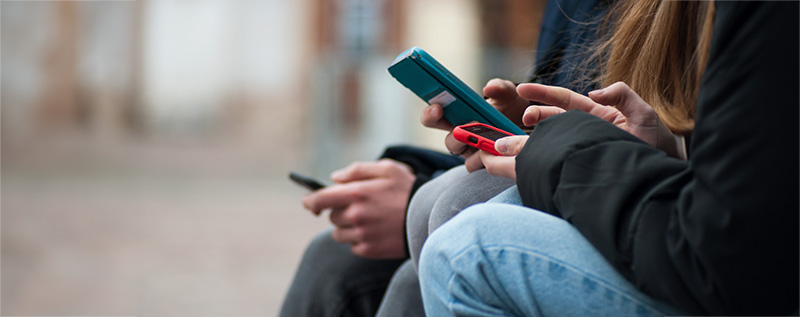 group of teens using smartphones