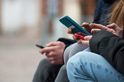 group of teens using smartphones