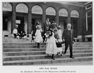 Harvey Burkhart walking down the Dispensary stairs with patients