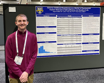 Kegan Shreffler in front of a poster