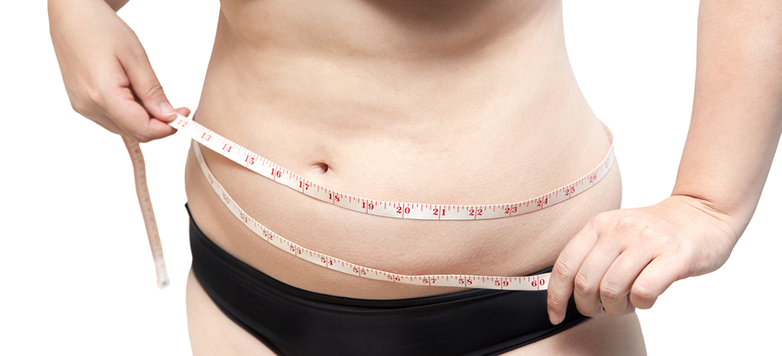 Woman with measuring tape around stomach