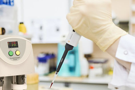 Hand pipetting a sample onto a device