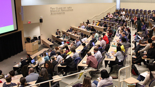 people in auditorium watching presentation