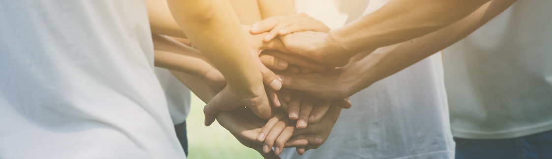 a group of people with there hands on top of each other