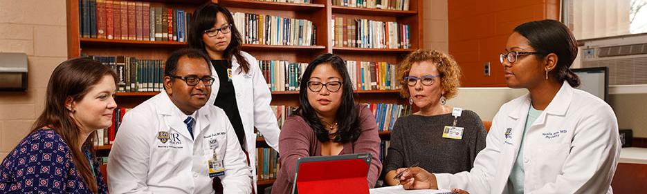 group of psychiatry faculty at table discussing data