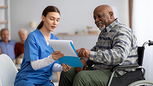 nurse talking to patient in wheelchair