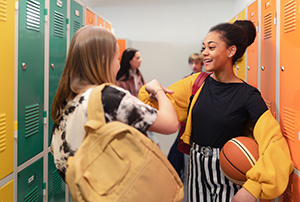 two students greeting each other in locker room