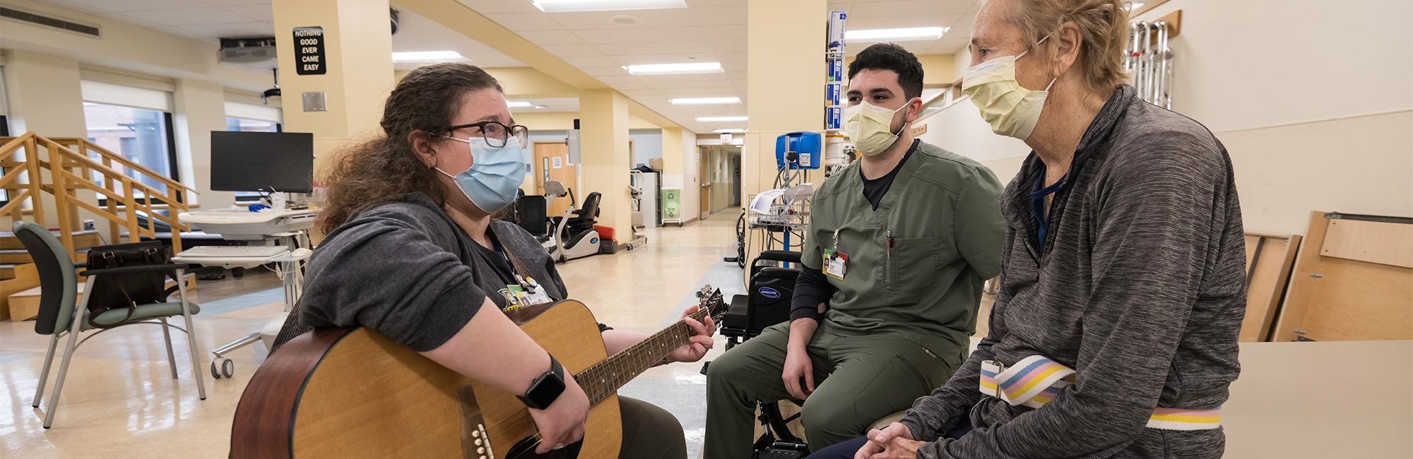 Woman Playing Guitar with 2 Men Listening